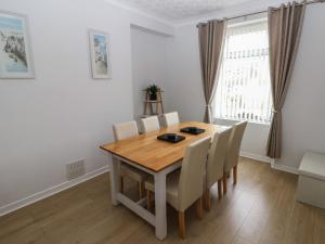 a dining room with a wooden table and chairs at Brynawel in Burry Port