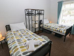 a bedroom with two beds and a window at Brynawel in Burry Port