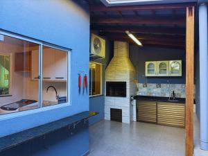 a kitchen with blue walls and a kitchen with a fireplace at House in Yolanda Village in Foz do Iguaçu