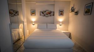a bedroom with a white bed and a mirror at Antonella's sweet home AIRPORT ORIO AL SERIO in Stezzano