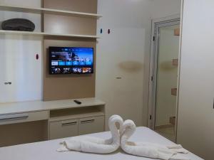 a bedroom with swan towels on a bed with a television at House in Yolanda Village in Foz do Iguaçu +27 photos