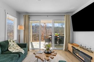a living room with a green couch and a large window at Roark Home Suites - Branson Landing, Gym, Indoor Pool in Branson