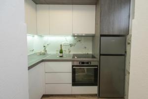 a kitchen with white cabinets and a bottle of wine at Apartment Center in Kolašin