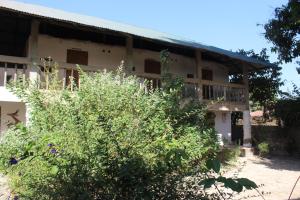 a building with a bush in front of it at Campement Emanaye in Oussouye