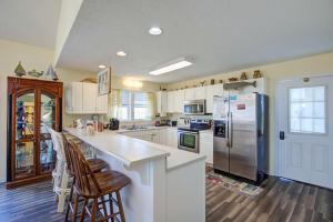 a kitchen with white cabinets and a stainless steel refrigerator at NTBHC636 Whale Den in North Topsail Beach