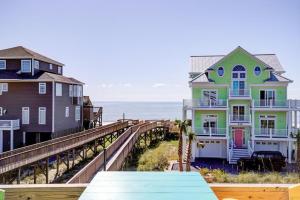 a row of houses on a pier next to the ocean at NTBHC636 Whale Den in North Topsail Beach