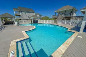 a swimming pool with blue water in front of a house at NTBHC636 Whale Den in North Topsail Beach