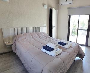 a bedroom with a large bed with towels on it at Terroir Village - Complejo en Mendoza in Guaymallen +53 photos