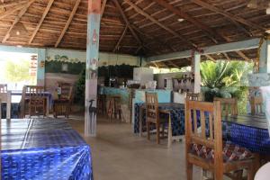 a restaurant with tables and chairs and a kitchen at Campement Emanaye in Oussouye