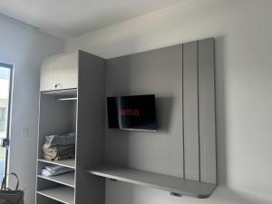 a gray cabinet with a tv on a wall at Condomínio Vila Eco Barra apto 215 in Barra Grande