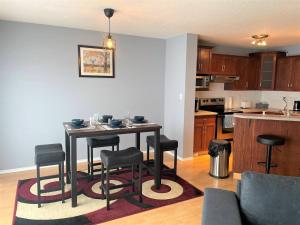 a kitchen with a table and chairs in a room at Spacious Duplex in Camrose