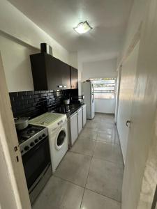 a small kitchen with a stove and a washer at Departamento Palomar in Posadas +7 photos