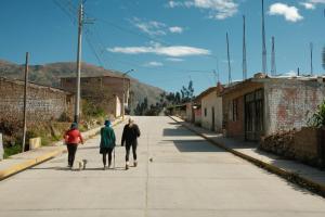 three people walking down a street with a dog at Dionny's House in Tinco