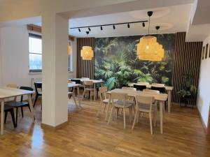 a dining room with tables and chairs and a mural at Gdańska Szkoła Szermierki in Gdańsk