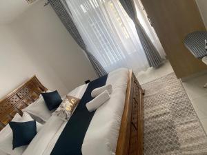 a bedroom with a large bed with blue pillows at Urbanza Haven Nakuru in Nakuru