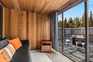 a screened in porch with a couch and a table at Meadow House 70 - Meredith Lodging in Sunriver