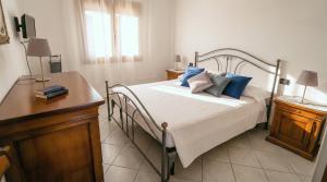 a bedroom with a bed with blue pillows on it at Cavour Apartment With Terrace in Palau