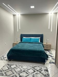 a bedroom with a green bed and two night stands at Με θέα το Κάστρο Apartment in Nafpaktos
