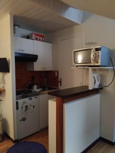a small kitchen with a microwave on a counter at Super central studio in Cauterets