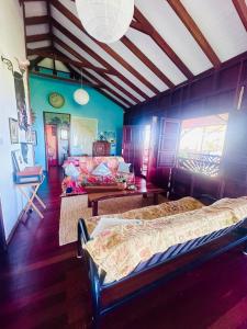 a room with two beds and a couch in it at Hummingbird House in Calibishie