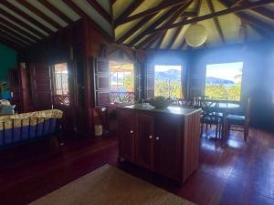 a living room with a table and chairs and windows at Hummingbird House in Calibishie