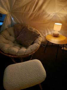 a room with a chair and a table with a lamp at Skaland panorama in Senja