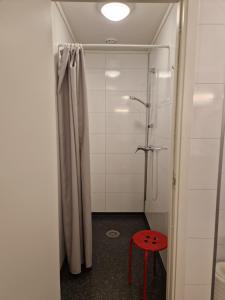 a bathroom with a shower and a red stool at Skaland panorama in Senja