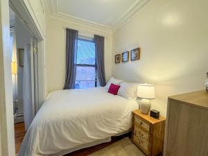 a bedroom with a white bed and a window at Cozy 1Bed, 1Bath in Brookline, MBTA in Brookline