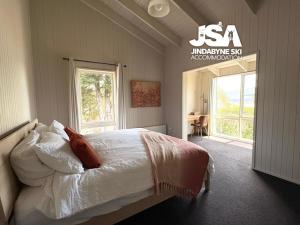 a bedroom with a bed with white sheets and a window at Kalkite Cottage in Kalkite