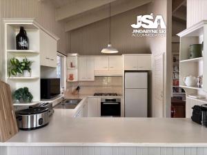 a kitchen with white cabinets and a white counter top at Kalkite Cottage in Kalkite