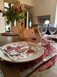 a plate sitting on a table with wine glasses at Gîte Bohême in Donchery +3 photos