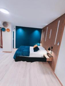 a bedroom with a large bed with a blue wall at Ocean Bleu Toulouse in Toulouse