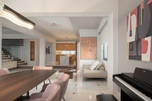 a living room with a table and a piano at Villa Kalliston - 4000m2 of Elevated Living in Rethymno +99 photos
