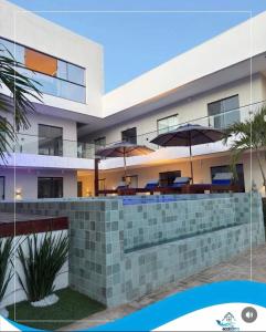 an exterior view of a building with tables and umbrellas at Condomínio Vila Eco Barra apto 215 in Barra Grande