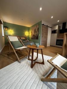 a living room with a table and a bed at La suite canopée en Brocéliande in Campénéac +7 photos