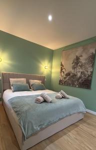 a bedroom with a bed with two towels on it at La suite canopée en Brocéliande in Campénéac