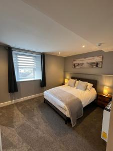 a bedroom with a large bed and a window at The Globe Apartments and Bedrooms in Cockermouth