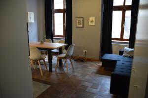 a dining room with a table and chairs and a blue couch at Apartment Tomasza 8 in Krakow