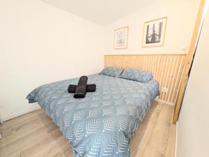 a bedroom with a bed with a black hat on it at Suite Évasion Spa - Tiny House in Vernouillet