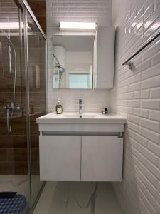a white bathroom with a sink and a mirror at Caesar Resort & SPA & Apartments Spacious Studio in Avgorou +69 photos