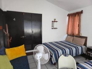 a bedroom with a bed and a fan in it at Cómoda habitación Mar in Veracruz