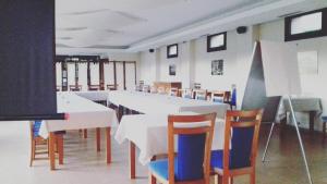 Un gran comedor con mesas y sillas blancas. en Hotel Ibaigune, en Murueta 36 fotos más