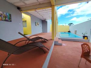 a patio with chairs and a swimming pool on a building at Casa Mineira - Flats novos em Ponta de Mangue - Maragogi in Maragogi