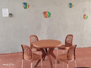 a wooden table and chairs with kites on the wall at Casa Mineira - Flats novos em Ponta de Mangue - Maragogi in Maragogi