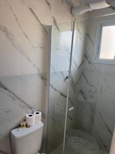 a bathroom with a toilet and a glass shower at Apartamento com Custo Benefício Imbatível in Passo Fundo