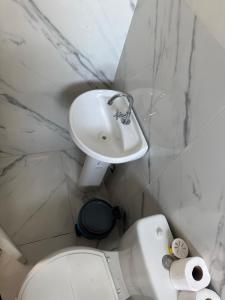 a white bathroom with a sink and a toilet at Apartamento com Custo Benefício Imbatível in Passo Fundo