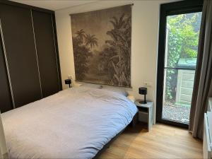 a bedroom with a bed with a painting on the wall at Bad Hoophuizen Chalet L-Cube 6 Nr Eik 19 in Hulshorst