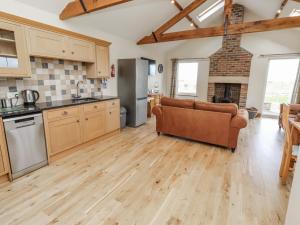 a kitchen with wooden floors and a couch in a room at Grey Croft in Embleton