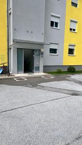 a yellow and gray building with a bike in front of it at Familien Apartment in Niederaigen
