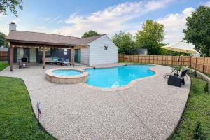 a swimming pool in the backyard of a house at DFW Retreat - Pool, Spa & Minutes to Dallas & Fort Worth in Flower Mound